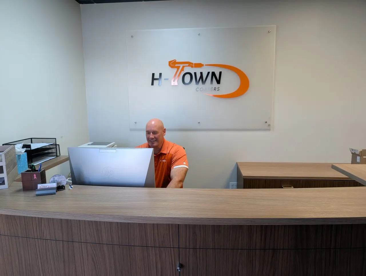 H-Town Coaters owner Jarrod Hammer working on a computer in the Houston front office — providing hands-on leadership, customer support, and expert powder coating guidance.